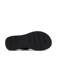 Black rubber shoe sole with textured finish. Five horizontal grooves for traction are visible. Designed for durability and grip.