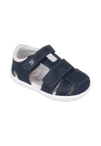 Sandalia de cuero azul marino con acentos en blanco, diseño de punta abierta, dos correas de Velcro ajustables y lados perforados para transpirabilidad.