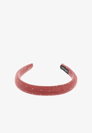 Diadema de terciopelo en color rosa empolvado con lunares blancos. Forma redondeada, textura suave y con etiqueta de la marca en el interior.