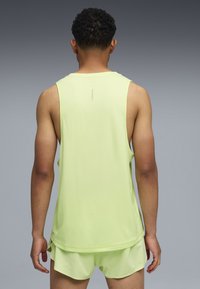 Αθλητικό τοπ σε ανοιχτό πράσινο χρώμα με απαλό ύφασμα και άνετη εφαρμογή, με μικρό λογότυπο της μάρκας τυπωμένο στην πλάτη κοντά στον λαιμό.