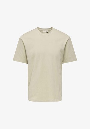 Beżowy, teksturowany t-shirt z krótkim rękawem i okrągłym dekoltem, o luźnym kroju, z widoczną metką marki wewnątrz kołnierza.