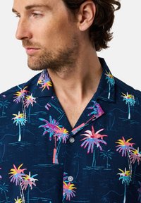 Marineblauwe short-sleeve shirt met een palmboompatter in levendig roze, geel en blauw. Met button-down kraag en lichte stof.