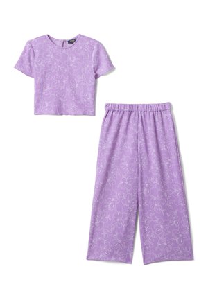 Lila cropped top met korte mouwen en bijpassende wijde broek met witte bloemprint en elastische tailleband, plat gelegd op een witte achtergrond.