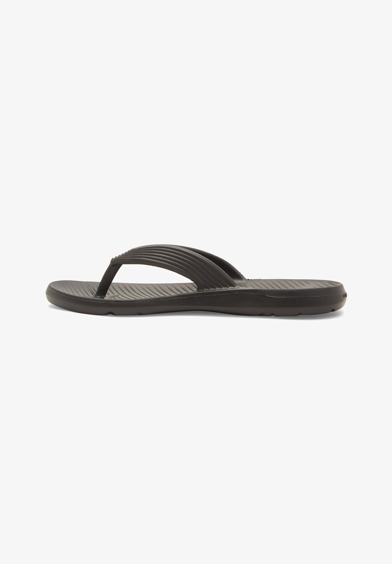 Black flip-flop sandal made of rubber, featuring a textured upper strap with horizontal grooves and a flat, cushioned sole.