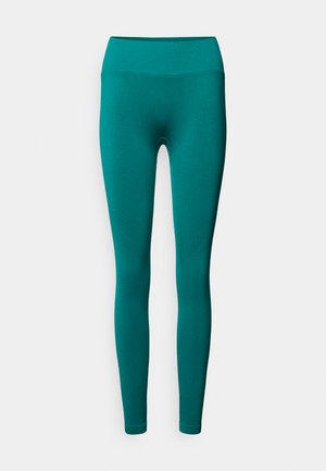 Leggings bleu sarcelle en tissu extensible avec une taille haute élastique. Coupe ajustée se resserrant vers la cheville, texture lisse, sans coutures visibles.