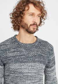 Strickpullover mit einem strukturierten Muster in verschiedenen Blau- und Grautönen, mit Rundhalsausschnitt und gerippten Bündchen.