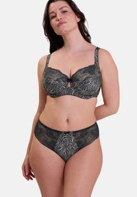 Soutien-gorge en dentelle noire avec culotte assortie, décorés de motifs floraux, de bords festonnés et d'un détail en forme de clé au centre du soutien-gorge.
