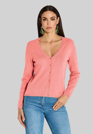 Korallfarbener V-Ausschnitt-Cardigan mit langen Ärmeln, mit einer Knopfleiste und geripptem Saum. Kombiniert mit blauen Jeans, vor einem grauen Hintergrund.