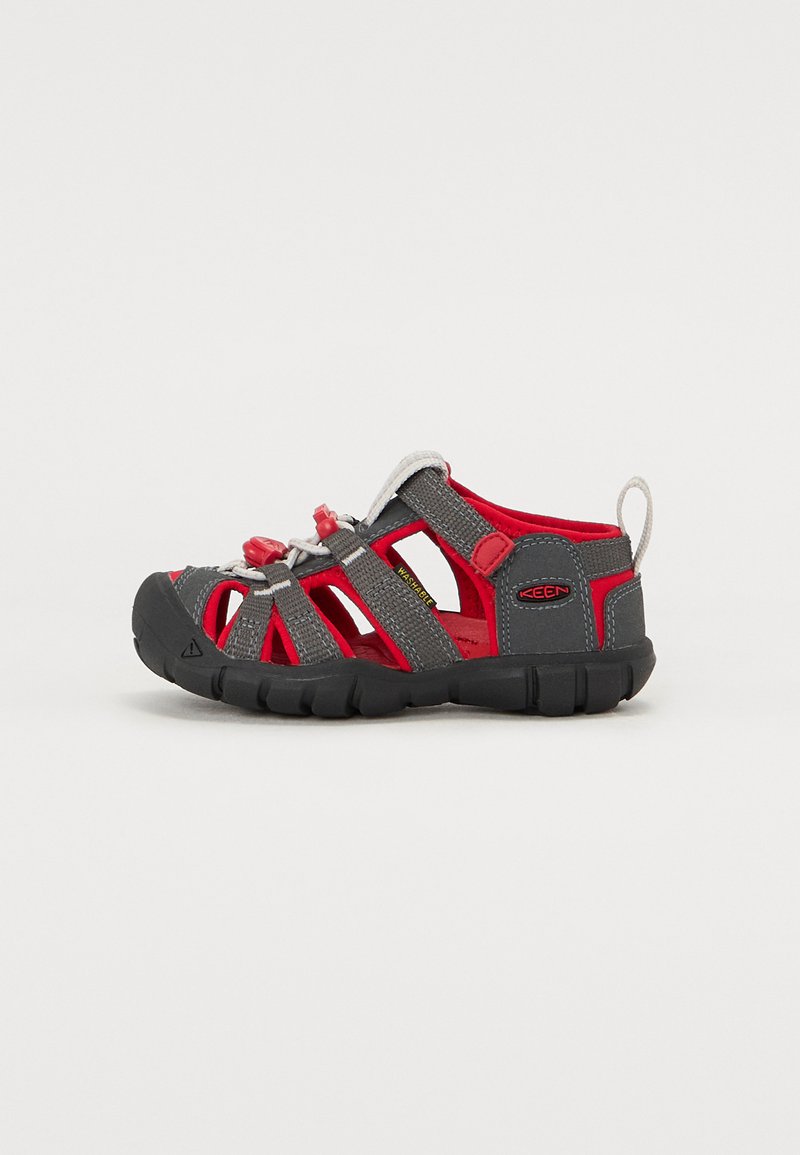 Gray and red sandal with an open design, elastic lacing, and rubber sole. Features breathable mesh and a rear pull tab for easy wear.