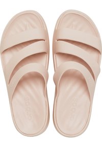 Des sandales de glisse rose clair en matériau en caoutchouc doux, avec trois larges brides sur le dessus et une semelle intérieure rembourrée.