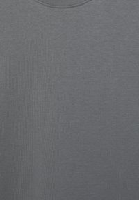 Maglietta a girocollo grigio scuro con una fine trama di tessuto a costine, mostrata distesa su uno sfondo neutro.