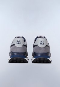 Ein Paar graue und marineblaue Sneakers mit schwarzen Sohlen und einem "N"-Logo auf der Rückseite, von hinten auf einem weißen Hintergrund gezeigt.
