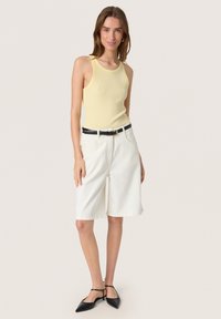 Yellow ribbed tank top, white denim shorts, black belt, and black pointed flats. Simple design with straight cuts and no visible patterns.