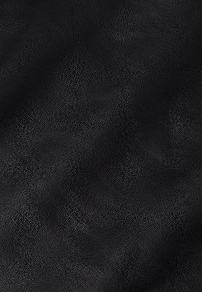 Crna tekstura kože s suptilnim naborima i finim detaljima zrna, prikazujući prirodne varijacije i nježne odraze.