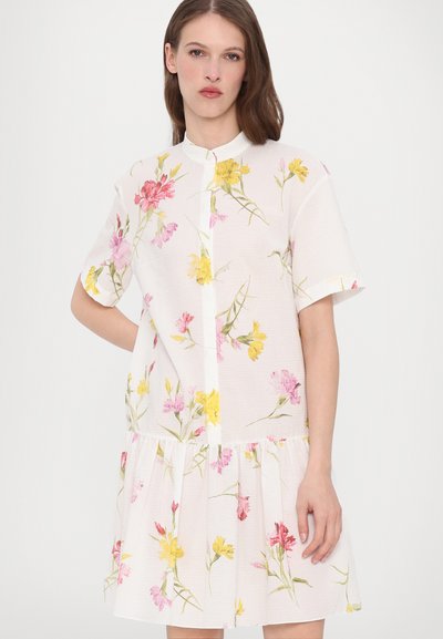 Short-sleeve, white dress with a floral pattern in pink and yellow, featuring a button-up front and tiered, gathered hemline.