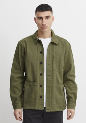 Olive green cotton jacket featuring a button-up front, two large front pockets, and a classic collar. Plain texture with black buttons.