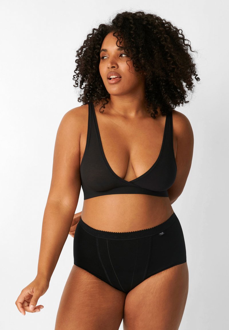 Bralette nera con scollatura a V profonda, spalline regolabili, abbinata a mutandine nere a vita alta con bordi ondulati e dettagli a pannello.