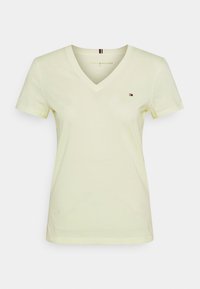 V-Ausschnitt T-Shirt aus leichtem, gelbem Baumwollmaterial, mit kurzen Ärmeln und einem kleinen Logo auf der Brust. Sanfte Textur mit lockerer Passform.