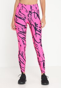 Leggings rosa con un motivo astratto in nero, vita alta e design aderente, realizzati in un materiale elastico e liscio.