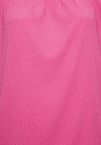 Texturovaná látka v živé růžové barvě; má jemný žebrovaný vzor. Materiál vypadá lehký a na dotek jemný.