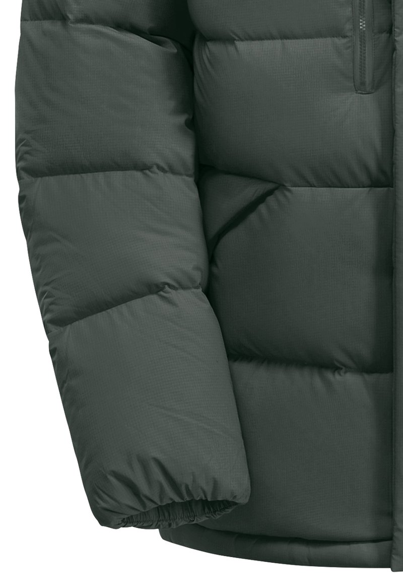 Grüne Pufferjacke mit horizontalen Steppnähten, glatter Textur, elastischen Bündchen und einer Reißverschlusstasche am oberen Arm.