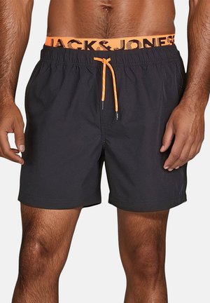 Black swim shorts with an elastic waistband featuring "JACK & JONES" in orange, and a matching drawstring for adjustment.