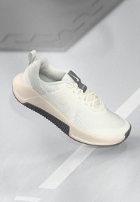 Nike παπούτσι σε απαλό κρέμα και γκρι χρώμα; πλέξη πάνω μέρος, υφή σόλας, στρογγυλή μύτη, σχέδιο με κορδόνια, εμφανές λογότυπο και θηλιά στο τακούνι.