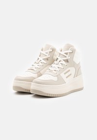 Baskets montantes en cuir beige clair avec des accents blancs, semelle texturée et lacets. Comprend des perforations pour la respirabilité et un détail de marque.