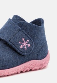 Marineblå filttoffel med en rosa gummisula, utrustad med en snäpplåsrem och en rosa snöflingebroderi på ovandelen.