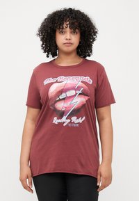 Maroon cotton t-shirt with short sleeves, featuring a graphic of lips and a lightning bolt, text "The Renegade" and "Rocking Rebel 95 Tour".
