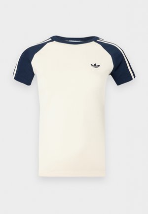 Krémová košile s krátkým rukávem a námořnicky modrými raglánovými rukávy, bílé pruhy na rukávech a malým černým logem Adidas na prsou.