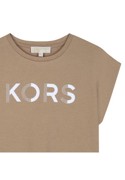 Μπεζ κοντομάνικο πουκάμισο με στρογγυλή λαιμόκοψη και λευκό στυλιζαρισμένο κείμενο "KORS" στο μπροστινό μέρος, με σχέδια από κουκκίδες στα γράμματα.