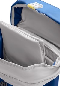 Blauer Rucksack, geöffnet, um mehrere gepolsterte Fächer und eine weiße Plastik-Schnalle am Klappe für sicheren Verschluss zu zeigen.
