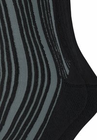 Schwarze und graue Socken mit strukturierten Streifen, kontrastierenden Rippmustern und aus weichem Strickmaterial. Sichtbare Details im Stoffdesign.