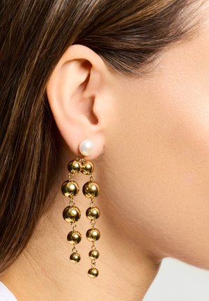 Pendientes llamativos dorados con un gran perno de perla en la parte superior y esferas doradas en cascada de diferentes tamaños, creando un efecto en capas.