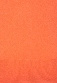 Maglione arancione brillante realizzato in un morbido tessuto a maglia, con una texture liscia e un orlo a coste alla base. Design semplice e monocolore.