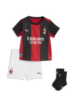 Maglia da calcio AC Milan a strisce rosse e nere con pantaloncini bianchi e calzini neri Puma disposti su sfondo bianco.