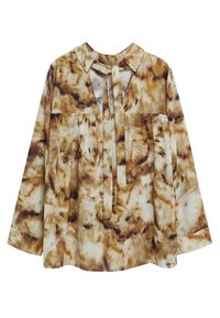 Langärmlige Bluse in Creme und Braun mit einem weichen, pelzigen Muster, ausgestattet mit einem Kragen und einer Bindung am Ausschnitt. Leichte Stoffqualität.