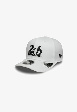 Casquette blanche avec visière incurvée et broderie "24h LE MANS" en noir. Comprend un ajustement extensible en élastique et des étiquettes de marque sur le côté.