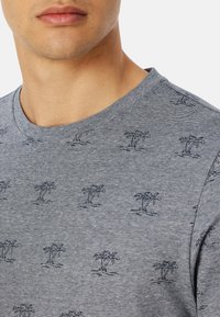 Grijze T-shirt met een ronde halslijn, voorzien van een subtiel gestreept patroon en kleine marineblauwe palmboomprints die gelijkmatig over de stof zijn verspreid.