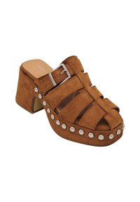 Mules en daim marron à bout ouvert avec un talon bloc, featuring des sangles verticales et des accents cloutés en argent le long de la semelle. Détail de boucle réglable.