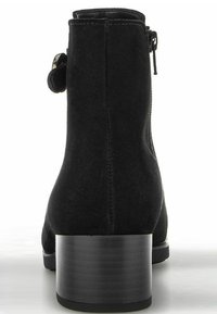 Bottine en suède noir avec un bout arrondi, fermeture éclair sur le côté et un large talon noir, présentant une texture lisse et des détails de couture subtils.