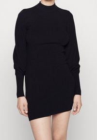 Abito in maglia nera con collo alto, maniche lunghe a sbuffo e silhouette aderente, caratterizzato da polsini a coste e lunghezza mini.