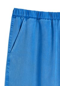 Niebieska spódnica z elastycznym paskiem w talii, z boczną kieszenią, ukazująca teksturę i detale szwów na tkaninie.