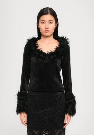 Black velvet top with a wide, fuzzy collar and furry cuffs. Paired with a black lace skirt featuring floral patterns.