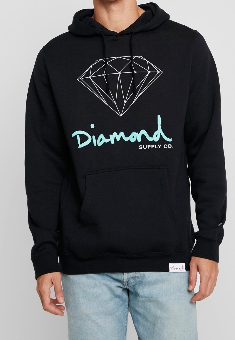 Svart hoodie i bomull. Har en geometrisk diamantlogotyp i vitt och ljusblått, med en framficka och tryckt varumärkesnamn.