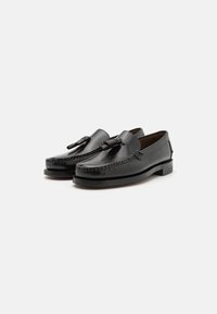 Sorte skinn loafers med en sydd design, med en framskjellende kvastdetalj og en lav, solid hæl. Glatt tekstur og polert finish.