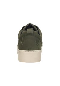 Groene suède sneaker met een ronde achterkant, lichtgekleurde rubberen zool en gestikte details. Inclusief een klein aantreklipje bij de hiel.