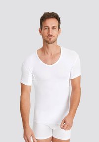 White short-sleeve t-shirt with a deep V-neck design and contrasting trim. Smooth texture, fitted shape, worn with white underwear.