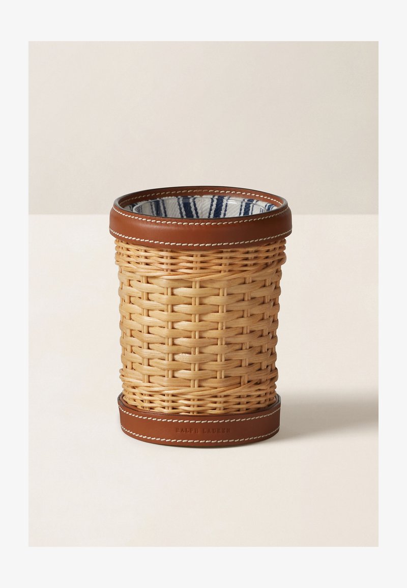 Vevd rattan kurv med en brun læring. Har et mønstret stoffinnlegg i blå og hvite striper. Rund form, strukturert overflate.